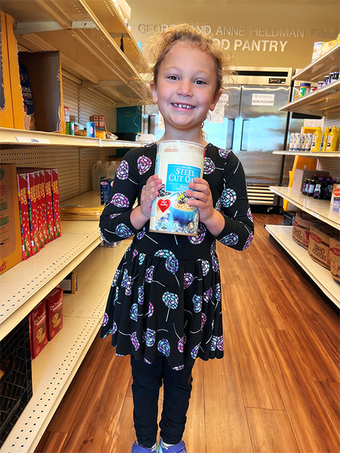 After collecting and purchasing nearly 500 items for Jewish Family Service Heldman Family Food Pantry, Sadie personally helped stock the shelves.
