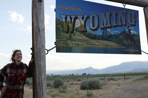 Bloggerin am Schild des Staates Wyoming