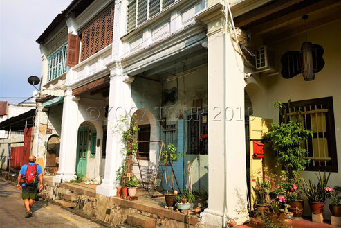 Un photographe marche dans les ruelles traditionnelles de George Town à Penang en Malaisie