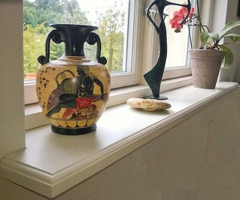 Eine weiße Holzfensterbank Innen verbaut in einem Raum mit Deko
