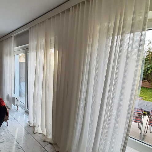 Moderne Gardinen in hellen Farben an bodentiefen Fenstern, montiert von Lamellen Junker im Main-Kinzig-Kreis
