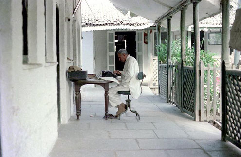 Feram translating documents for Lord Meher ; photo taken by David Fenster