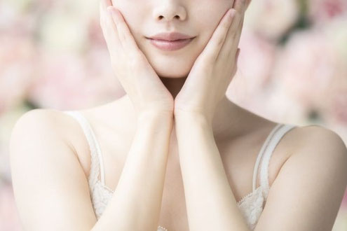 両手を顔に当てている女性