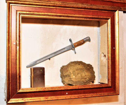 John Wayne mementos: a letter opener, gifted and inscribed to him from officers at Fort Benning while filming "The Green Berets"; the Zippo lighter Wayne gave to cast and crew, and the "Brannigan" belt buckle (Heritage auction 2014). 