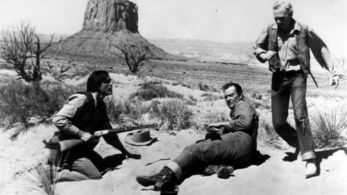 Monument Valley's Mitchell Butte in the background of this scene with John Wayne in "The Searchers".