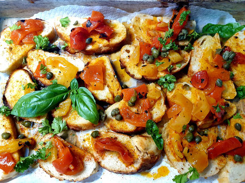 Griechische Bruschetta: Baguettebrotscheiben mit Paprika, Olivenöl und Weissweinessig belegt.