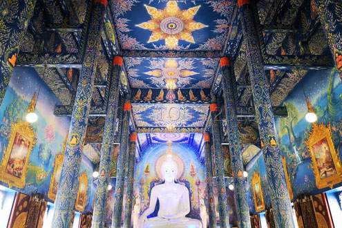 Un Bouddha blanc assis dans la salle principale du temple bleu de Chiang Rai