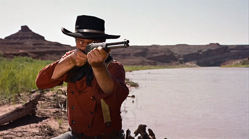 John Wayne on location on the San Juan River in "The Searchers", with Mexican Hat in the background.