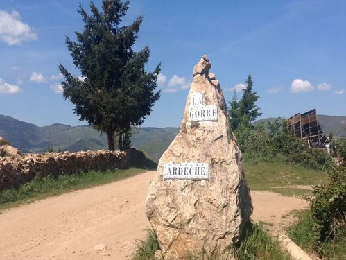 Un rocher blanc avec dessus deux pancartes indiquant l'entrée du domaine de la gorre par le gite de la gorre en location en ardeche