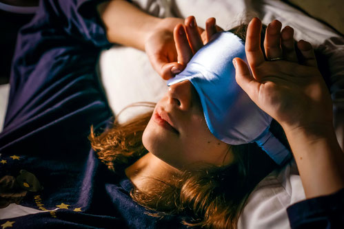 Frau mit Schlafmaske findet in der Nacht keine Ruhe