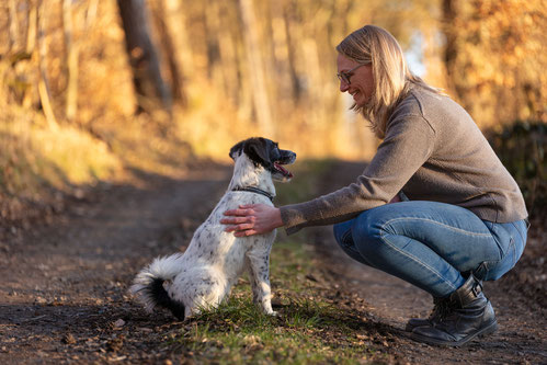 Lea Eisenacher (HUndetrainierin) mit ihrem Hund im Wald