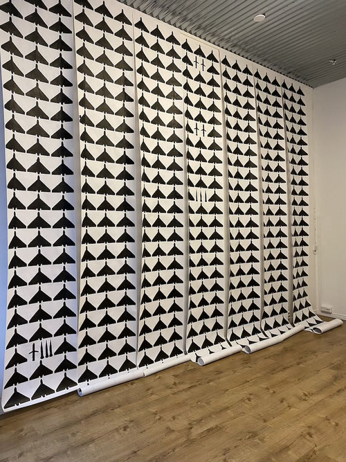 Graphic art installation of hand-printed drone and missile silhouettes on paper, How I Spent My Summer by atist Olga Drozd