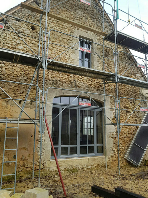 Maçonnerie de pierres de taille vieillies et patinées. Ouverture cintrée en anse de panier