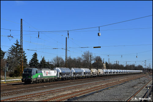 Am 03.03.2026 schleppt 193 215-1 einen langen Silowagenzug durch Leipzig-Wiederitzsch. Diesmal ist sie mit "RailLog" Werbung versehen