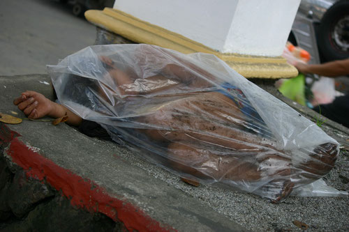 雨の日にプラスティック・シートを被って寝るストリート・チルドレン　マニラ市で