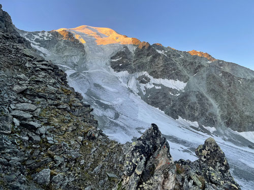 Die ersten Strahlen erreichen den schneebedeckten Gipfel des Petit Combin.