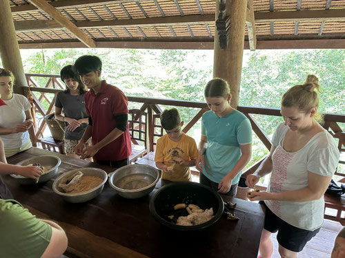 Zubereitung der Knödel für die Elefanten aus Bananen, Reismehl und Wasser