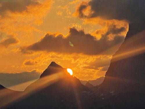 Die Sonne erscheint hinter dem Schwarz Stöckli neben der Gross Windgällen.