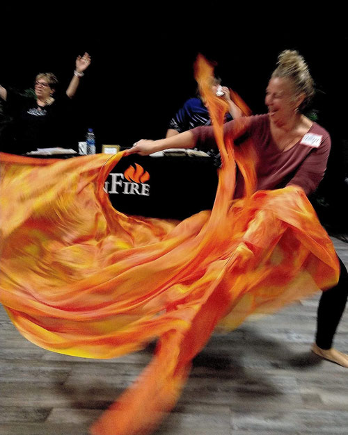 woman dancing with orange Fire Flags
