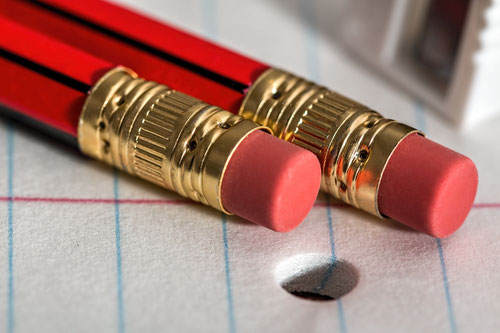 Bleistifte mit Radiergummis auf Schreibblock für Korrektorat