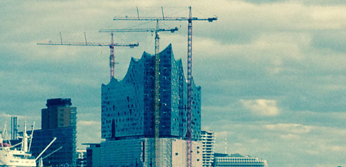 Projektmanagement-Training. Auf dem Bild sieht man die Baustelle der Elbphilharmonie in Hamburg. Es geht darum, durch gutes Training Projekte besser durchführen zu können.