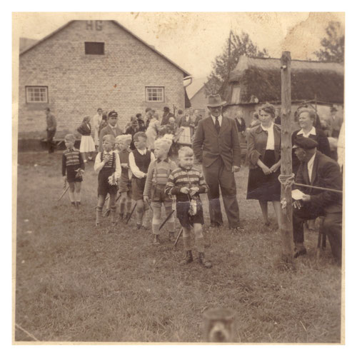 Dies ist ein Foto vom Kinderfest 1955. Im Wettkampf hatten die Jungen einen Holzstiel mit Pferdekopf (genannt Steckenpferd) und mussten, wie beim Ringreiten, einen Ring von einer Leine herunter holen. Das Kinderfest wird auch heute noch organisiert.