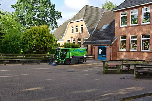 Der Schulhof wird gefegt.