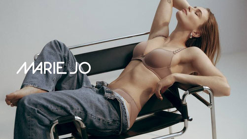 Model mit Marie Jo Avero BH und Rioslip gekleidet liegend sitzend mit Sportschuhen vor weißem Hintergrund.
