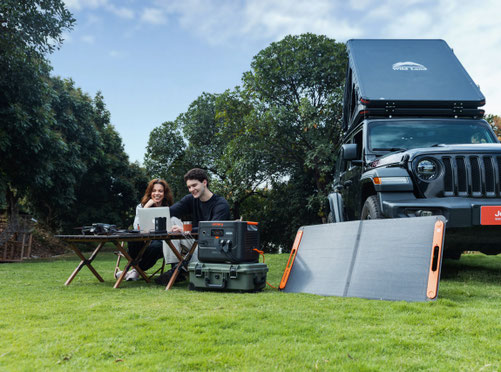 Menschen vor Camper mit Powerstation und Solarpanel 2026