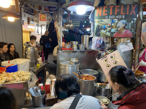 ristorante in un mercato notturno di Seoul, dove la protagonista di una docu-serie sul cibo, divenuta famosa su Netflix, cucina ravioli.