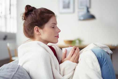 Hochsensible Frau nimmt sich Zeit für Regeneration bei einer Tasse Tee