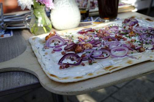 Foto vom Flammkuchen mit roten Zwiebeln und Speck