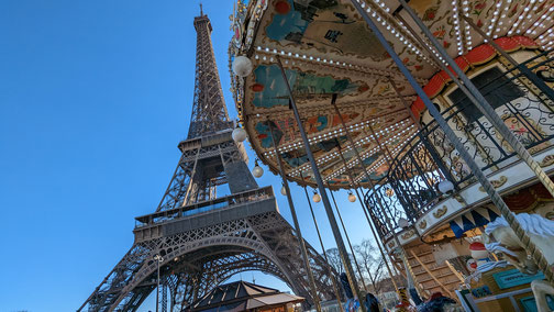 Ein Karussell und der Eiffelturm in Paris.