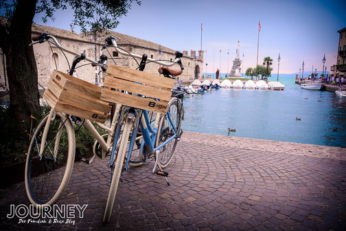 Zwei Fahrräder stehen im Hafen von Lazise, am Gardasee.