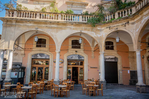 Ein Cafe in Catania von aussen, mit Stühlen auf der Terrasse.