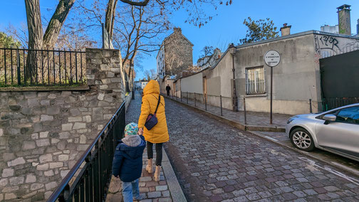 Frau mit Kind läuft durch Montmartre.