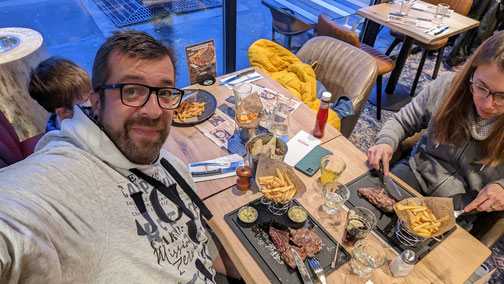 Ein Mann macht ein Selfie an einem Tisch in einem Restaurant.