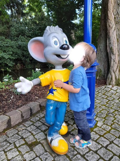 Ein kleiner Junge umarmt die Figur der Euromaus.
