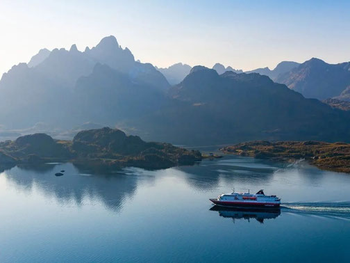 Hurtigruten Schiff vor norwegischer Küstenlandschaft