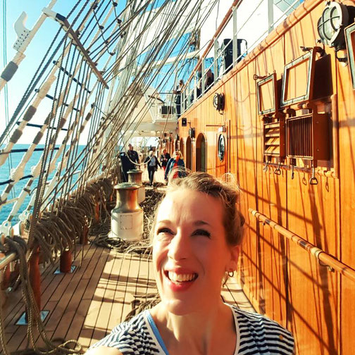 Friederike Willenborg von Emocean Cruises an Bord der Sea Cloud Spirit auf dem Sonnendeck des Großseglers bei strahlendem Wetter.