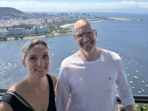 Zwei Erwachsene vor einer Bucht von Rio de Janeiro