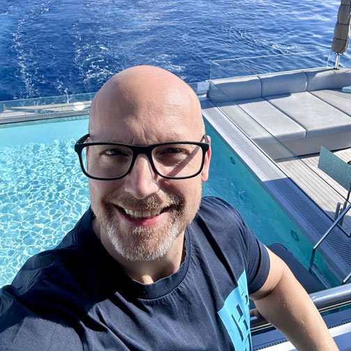 Timo Clarén von Emocean Cruises an Bord der Emerald Sakara mit Blick auf den Pool und das tiefblaue Meer.
