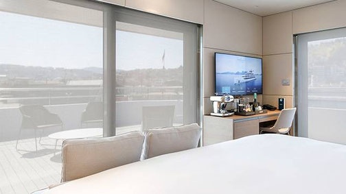 Terrace Suite der Superyacht Emerald Kaia mit modernem Schlafzimmer, Sitzbereich und großer privater Außenterrasse.