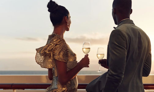 Paar steht mit Champagnergläsern an der Reeling von Crystal Schiff