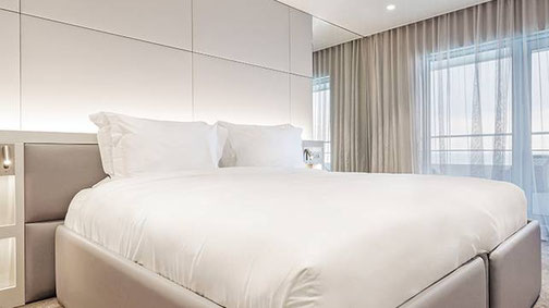 Helle Balkon Suite der Superyacht Emerald Kaia mit modernem Schlafzimmer und Zugang zum privaten Balkon.