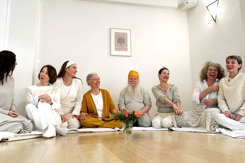 Eine Gruppe Kundalini Yoga Praktizierender ist fröhlich