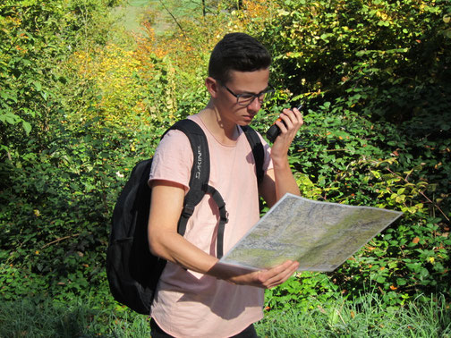 Teilnehmender unterwegs mit Karte und Funkgerät – erlebnispädagogische Orientierungstour für Schulklassen, Jugendgruppen und Firmen