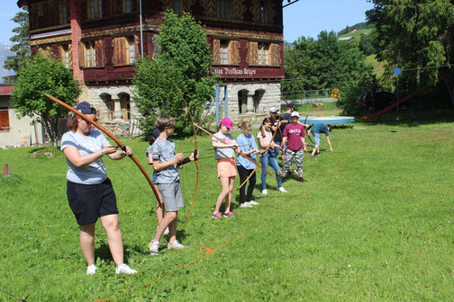 Schulklasse bei erlebnispädagogischem Schullager am Bogenschiessen - abenteuerliche all inclusive Pakete für Klassenlager