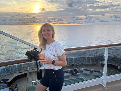 EXPLORA I - Anne Fischer von Emocean Cruises auf dem Deck des Schiffes im Hintergrund ein traumhafter Sonnenuntergang