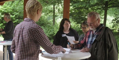 Foto: Besucher/innen eines Freilichtmuseums beim Ausfüllen von AfeB-Fragebögen (AfeB/ 2015)